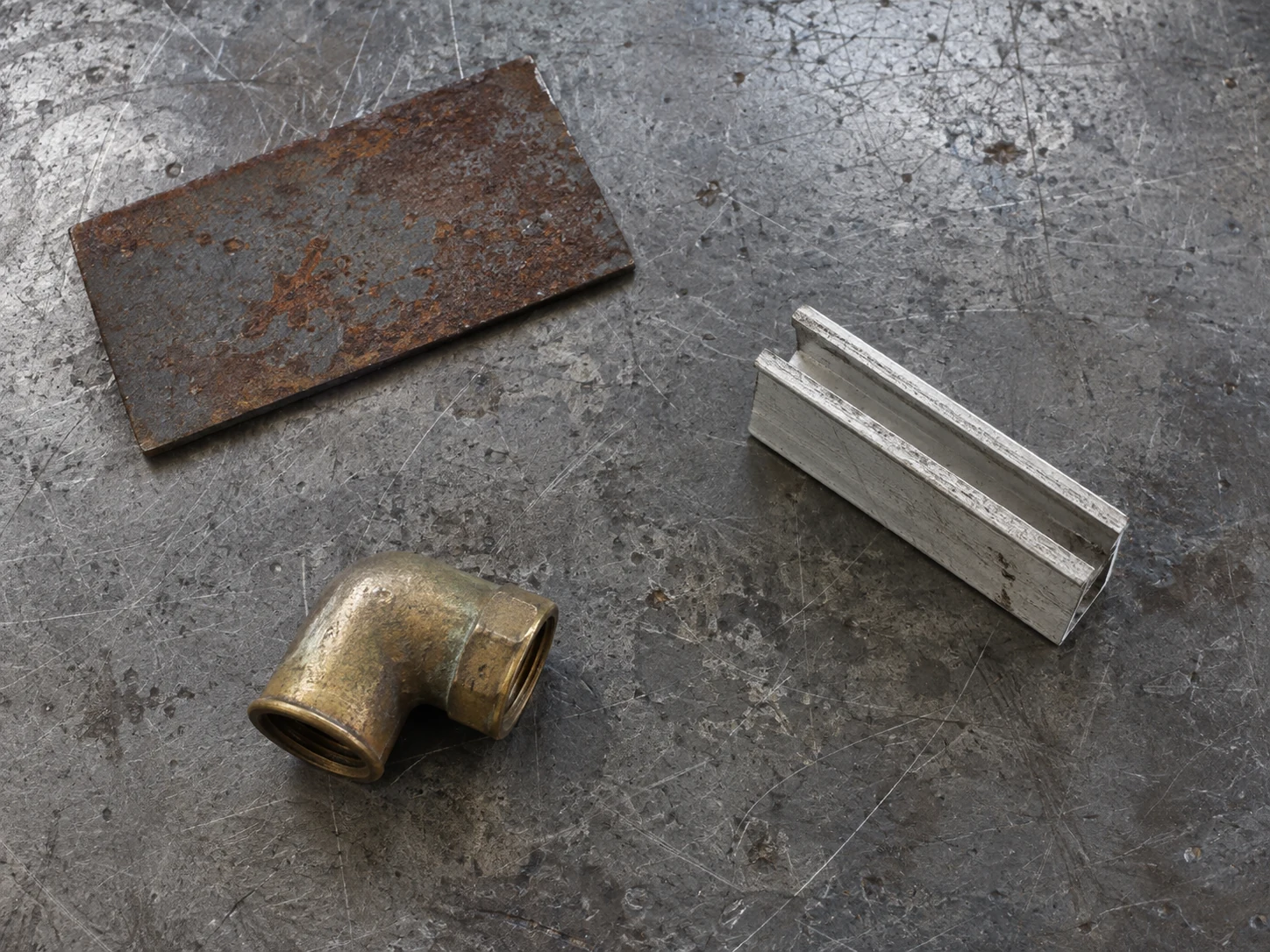 Tres muestras metálicas separadas sobre una mesa.